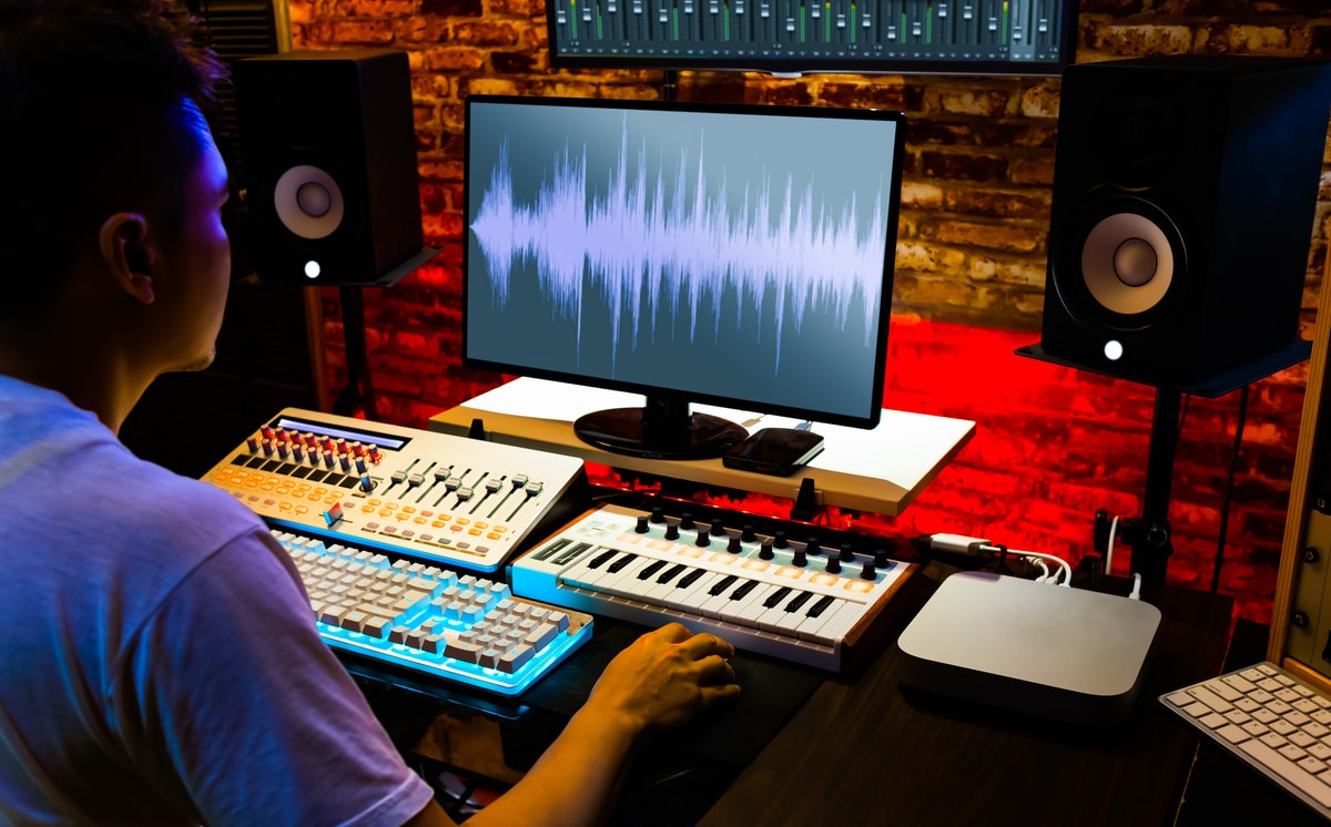 A photo of a young adult listening to sound waves on his music studio.